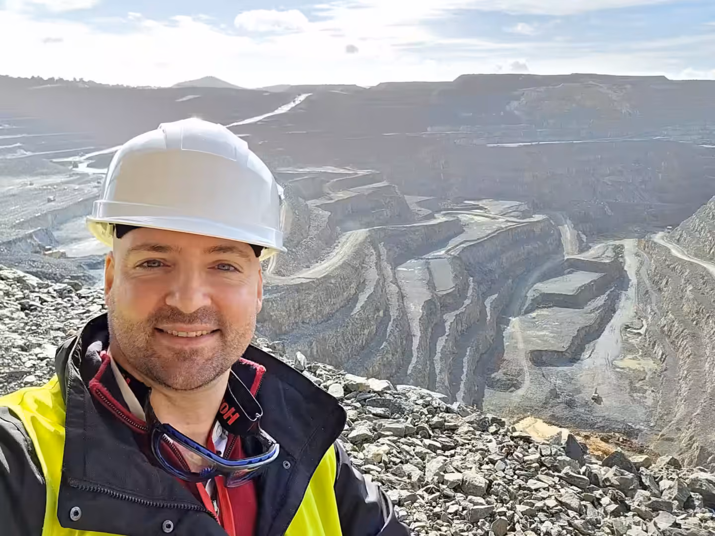 Thomas Gaultier in hard hat and high-visibility gear above a working open pit