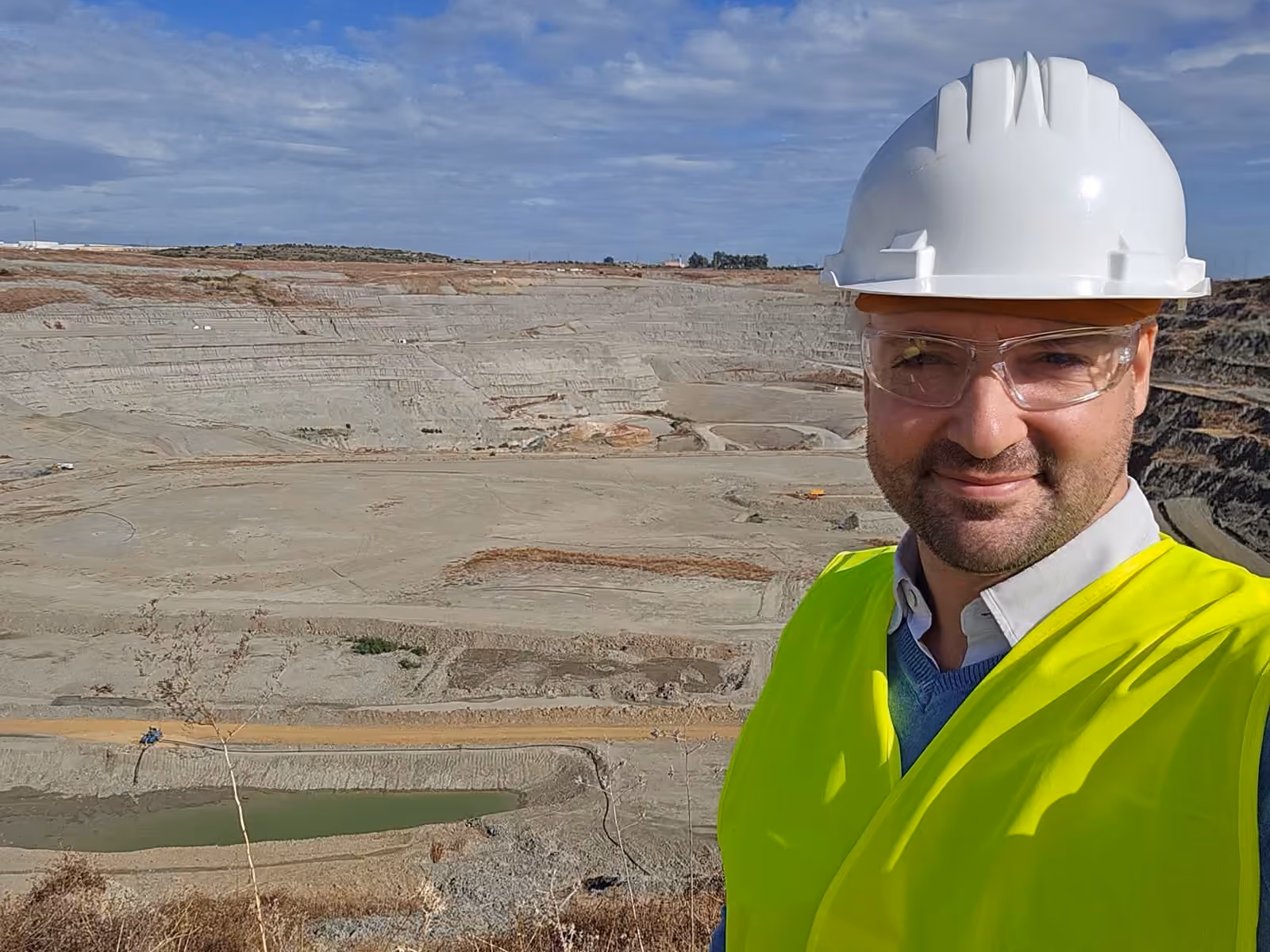 Thomas Gaultier in hard hat and high-visibility gear above a working open pit