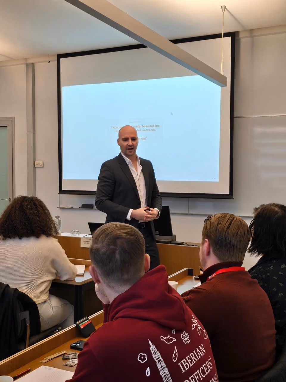 Thomas Gaultier teaching a university seminar, students seated in front of him
